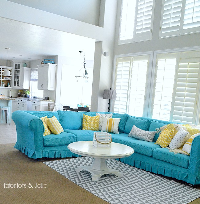 turquoise slipcover and yelllow and grey pillows