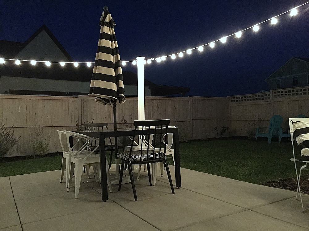 1 hour modern cafe light patio project. Use vinyl fence posts to create a modern way to display cafe lights in your yard. 