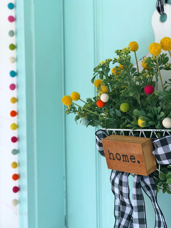 Spring Farmhouse Pom Pom Wreath - turn a wood organizer into a whimsical farmhouse wreath for your door! 