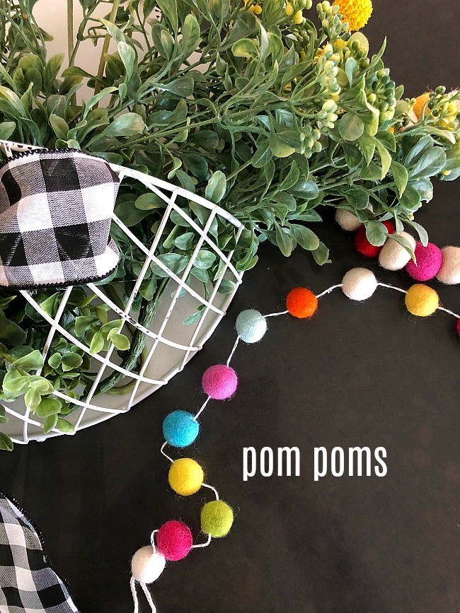 Spring Farmhouse Pom Pom Wreath - turn a wood organizer into a whimsical farmhouse wreath for your door! 