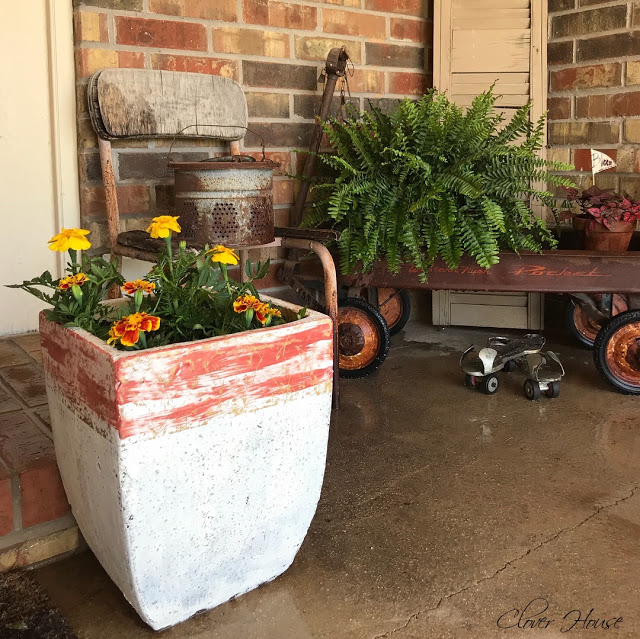 A rectangular container has been painted to look like concrete with orange streaks at the top of the pot.