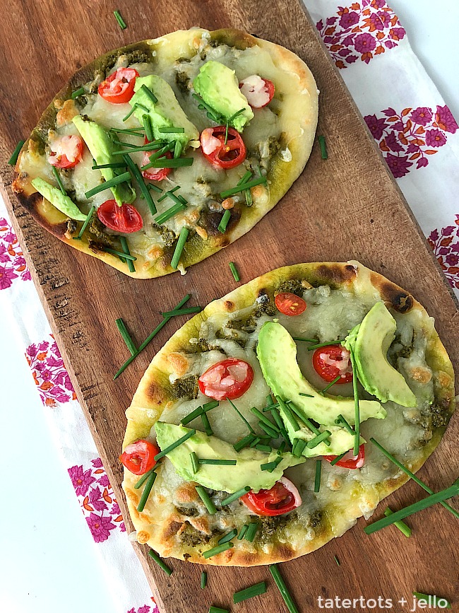 Avocado Naan Mini Pizzas are the perfect after-school snack OR easy dinner idea. Chewy naan bread topped with a creamy layer of guacamole, bubbly cheese and crisp tomatoes avocados, and chives. Kids can add whatever toppings THEY like! 