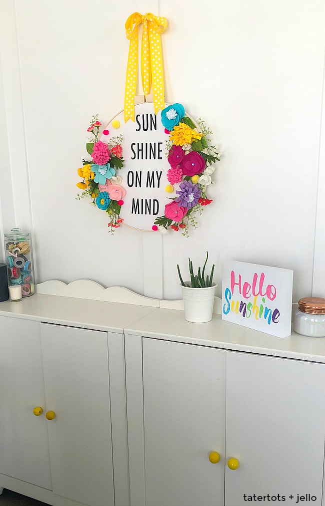 How to make a felt flower hoop saying wreath. Create a saying for spring and put it inside an embroidery wreath with felt flowers. It's fun to make and will welcome visitors to your home all summer long! 