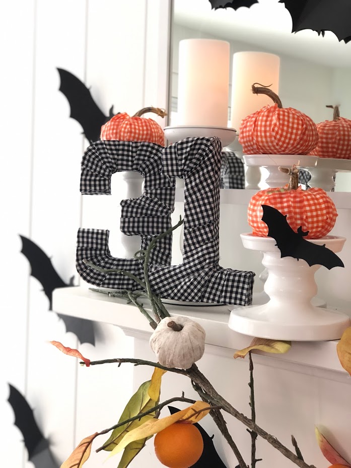 Halloween Bats in an Orange Orchard Mantel. Pumpkins on orange vines, farmhouse signs, decoupaged pumpkins and bats make a bright Halloween mantel with a slightly spooky side! 