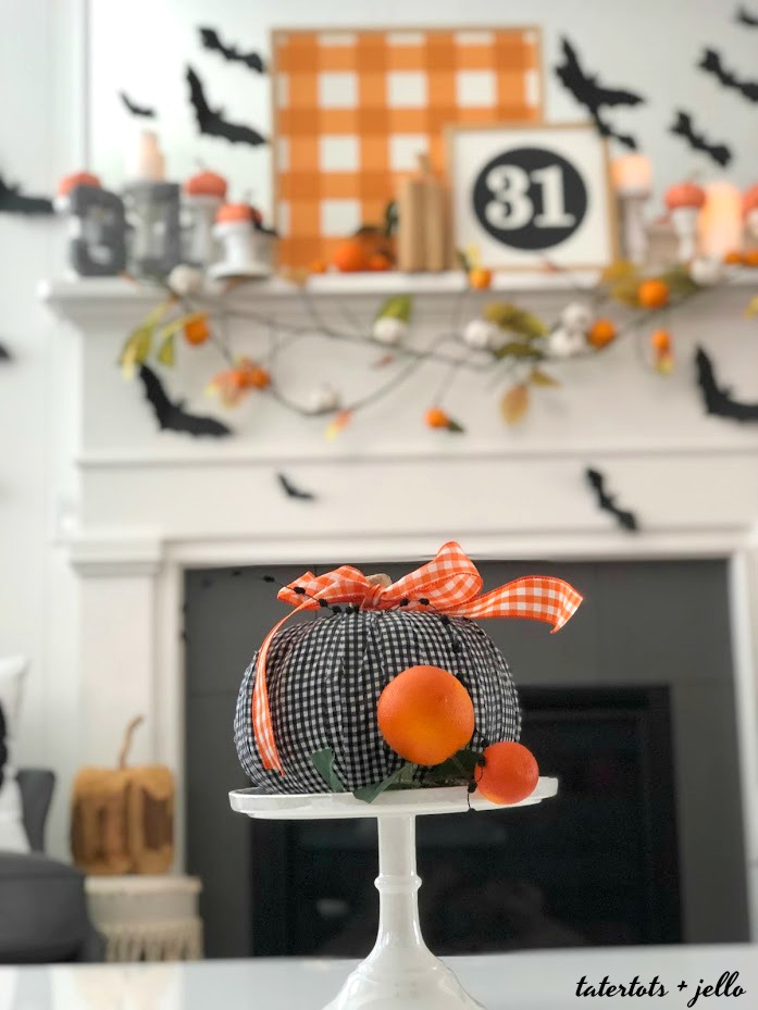 Halloween Bats in an Orange Orchard Mantel. Pumpkins on orange vines, farmhouse signs, decoupaged pumpkins and bats make a bright Halloween mantel with a slightly spooky side! 