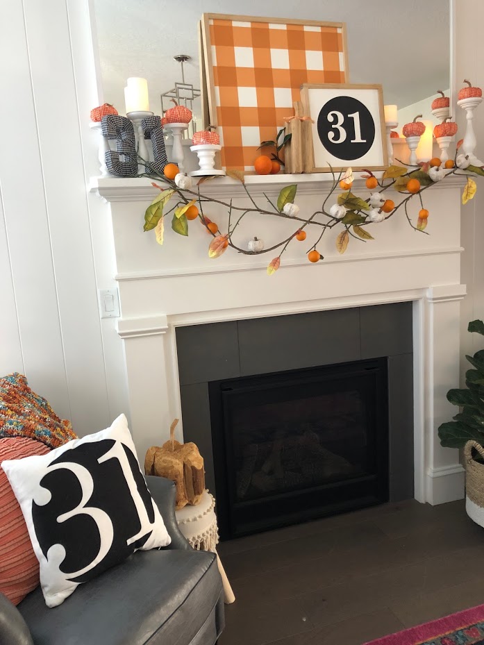 Halloween Bats in an Orange Orchard Mantel. Pumpkins on orange vines, farmhouse signs, decoupaged pumpkins and bats make a bright Halloween mantel with a slightly spooky side! 