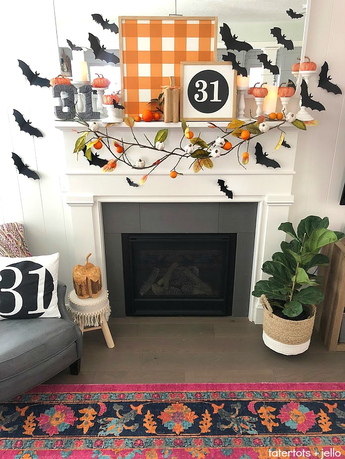 Halloween Bats in an Orange Orchard Mantel. Pumpkins on orange vines, farmhouse signs, decoupaged pumpkins and bats make a bright Halloween mantel with a slightly spooky side! 