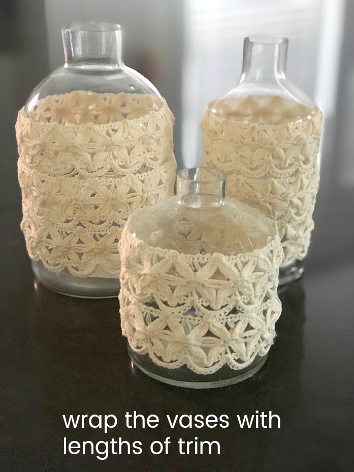 Anthropologie-Inspired Colorful Spring Vases DIY. Take simple jars, add spray paint and trim to create a beautiful centerpiece for a fraction of the cost! 