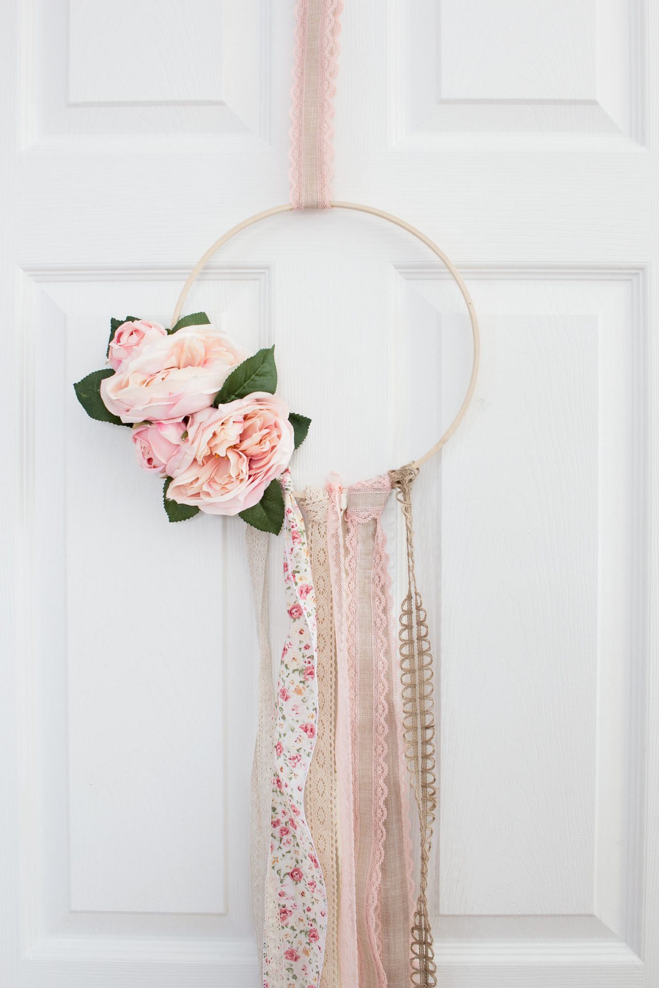 Boho hoop wreath with ribbons nad pink flowers.