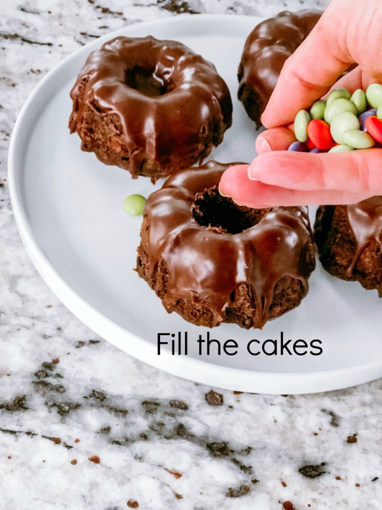 Halloween Cauldron Mini Cakes with Candy Inside! These tiny cakes are perfect for Halloween parties this year and kids will love biting inside to find a candy surprise.