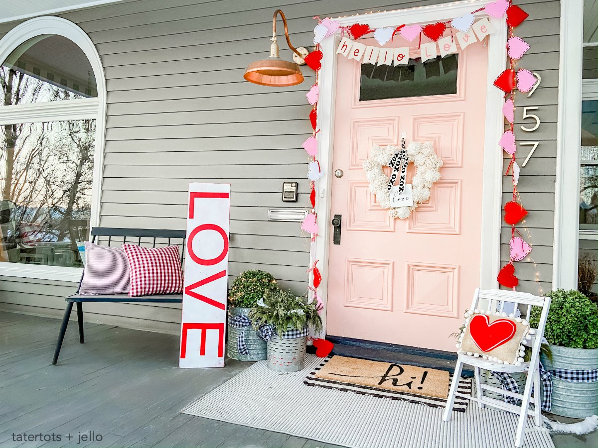 Pink and Red Valentine's Porch. Make a DIY garland, sign, banner, pillow and wreath to create a bright and colorful porch for Valentine's Day! 