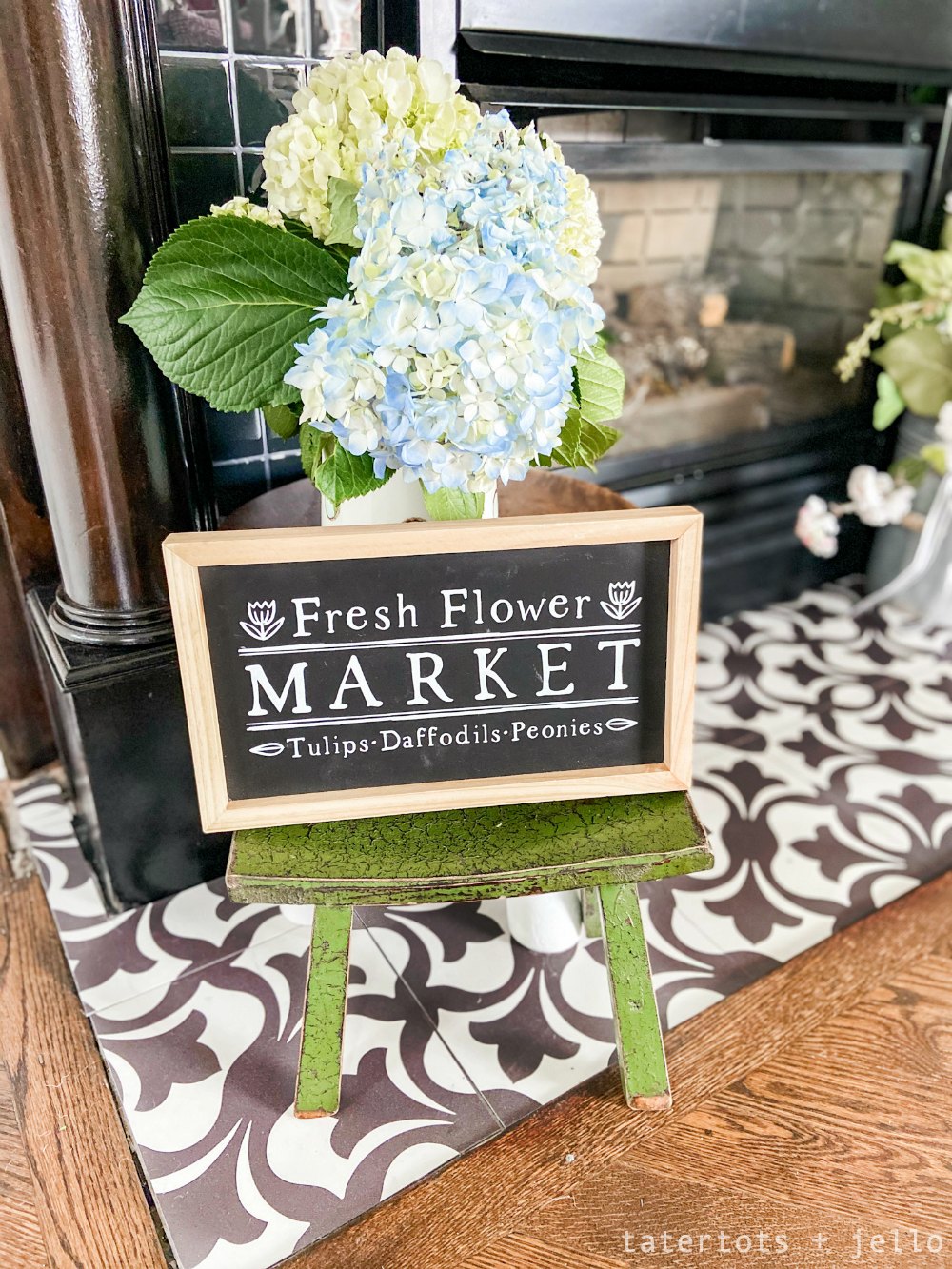 Simple Spring Flower Mantel. Colorful flower art, sweet vases of flowers and a handmade banner are easy to put together to bring some Spring sunshine to your mantel.