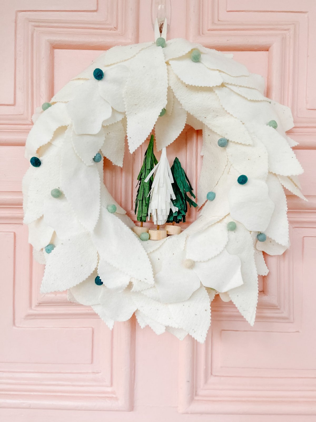 Anthropologie-Inspired Holiday Felt Wreath. Create a whimsical holiday wreath with layers of fluffy wool, felted balls and adorable tissue paper trees. 