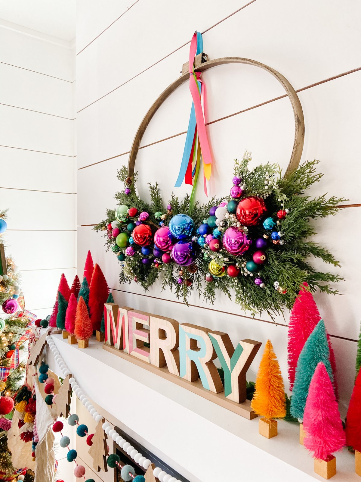 Bright Colorful Merry Mantel. Create colorful holiday cheer with a bright garland, little bottlebrush trees and an embroidery hoop ornament wreath!