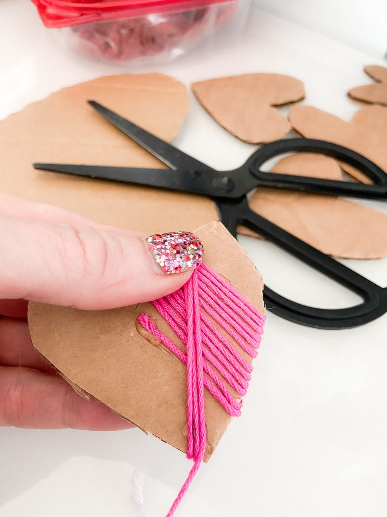 Valentine's Day Yarn-Wrap Cardboard Hearts + Centerpiece. Yarn-wrapped cardboard hearts are so simple to make and can be used for all kinds of Valentine's Day crafts. Add them to clear jars for a pretty centerpiece idea!