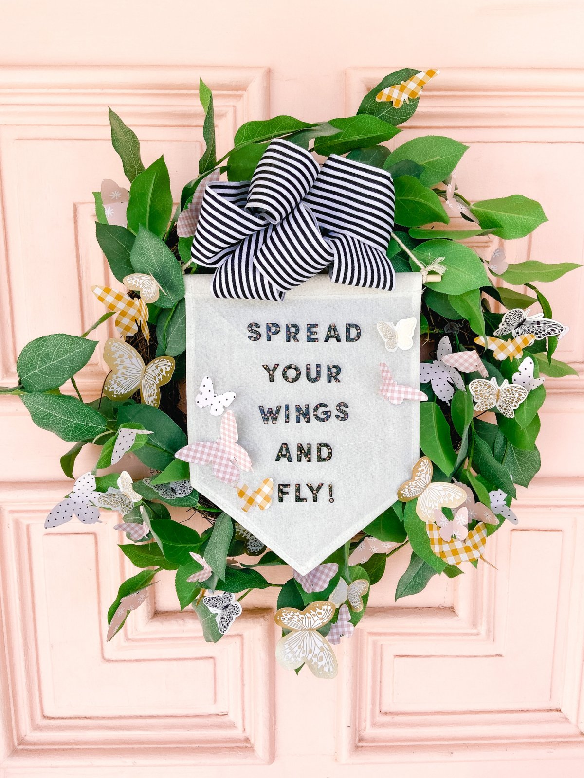 Spring Butterfly Pennant Wreath. Celebrate spring by making this simple wreath with butterflies cut out of cardstock and a big pennant in the middle and a spring saying!