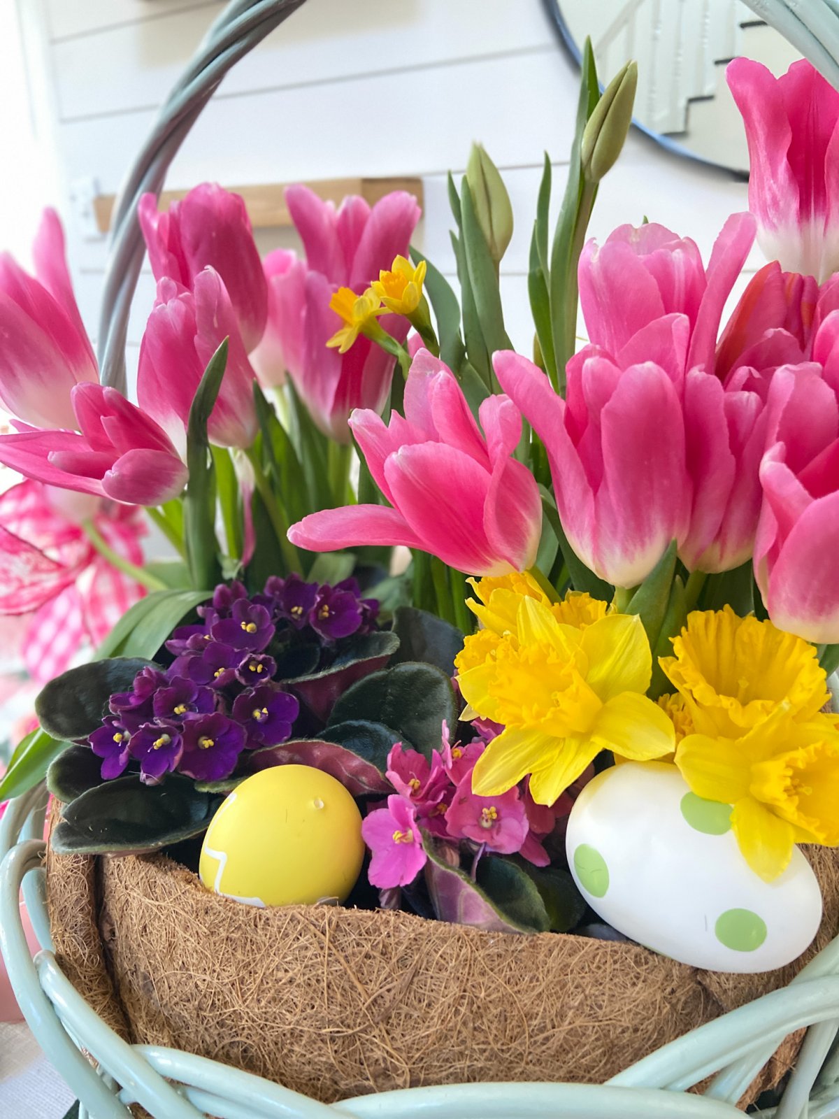 Easter Basket Living Floral Centerpiece. Take an Easter basket, plant flowers inside and cover with a dollar store coir liner for a beautiful spring living centerpiece.