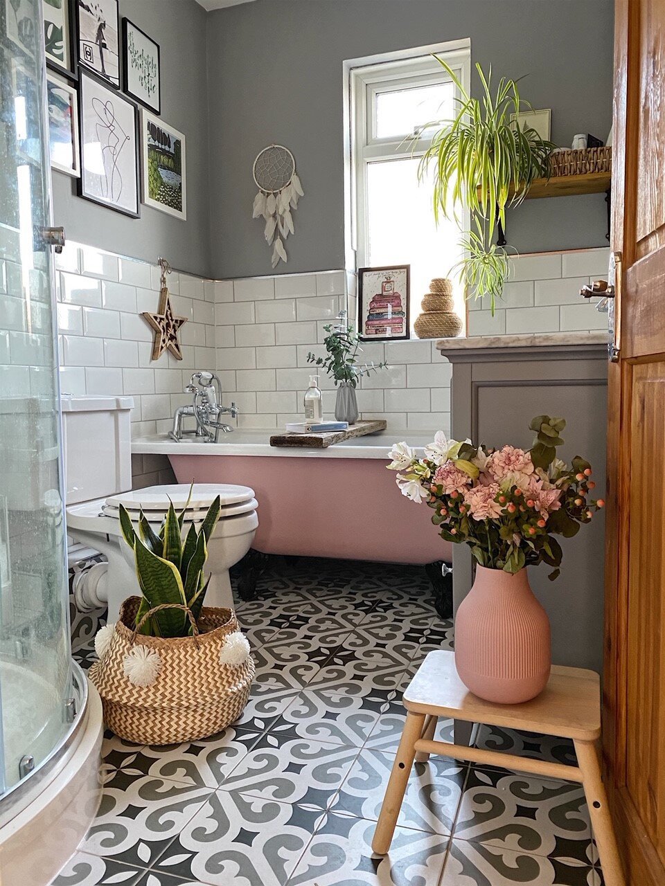 Pink clawfoot tub with modern mosaic tile.