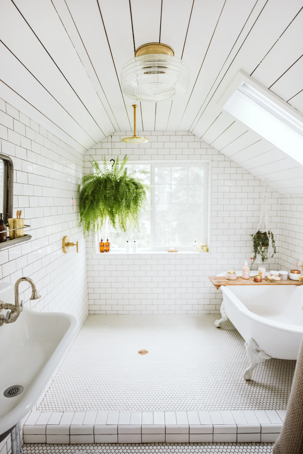 Attic bathroom with subway and penny tile plus white clawfoot tub.