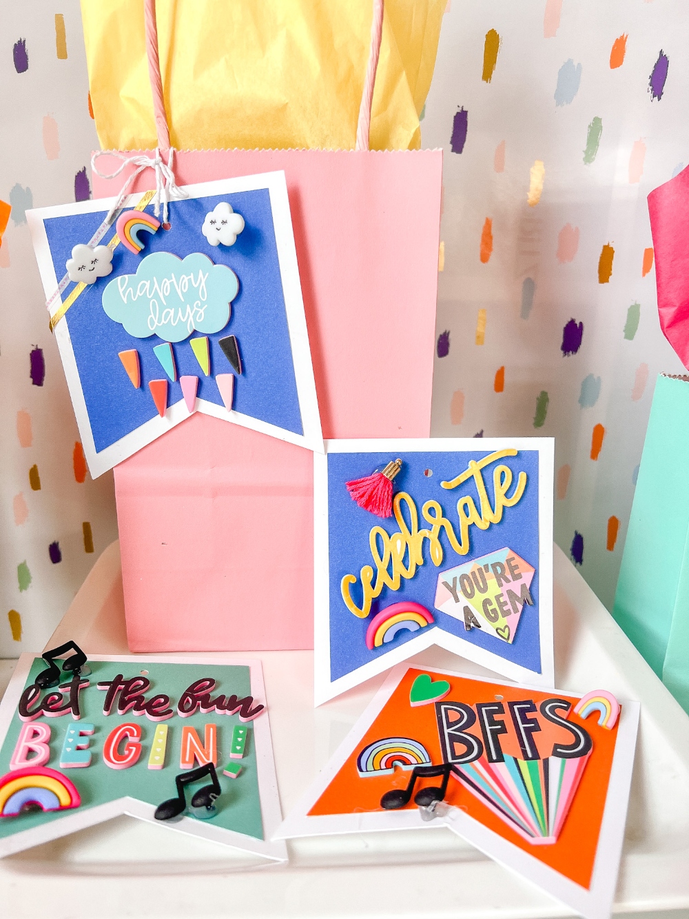 Bright and colorful gift tags with sayings and buttons attached.