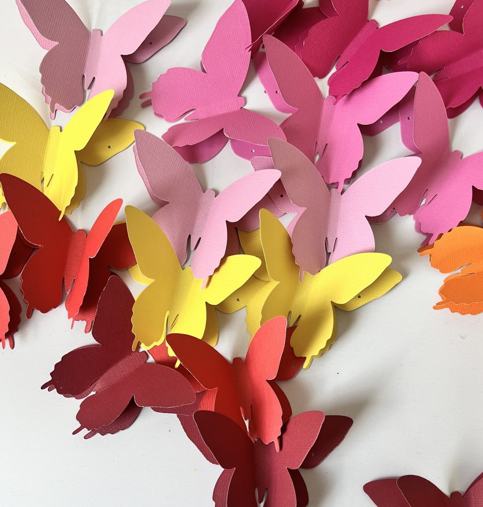 Easy Rainbow Butterfly Spring Wreath. Cut butterflies out of pretty paper for a happy rainbow wreath you can use all summer long! 