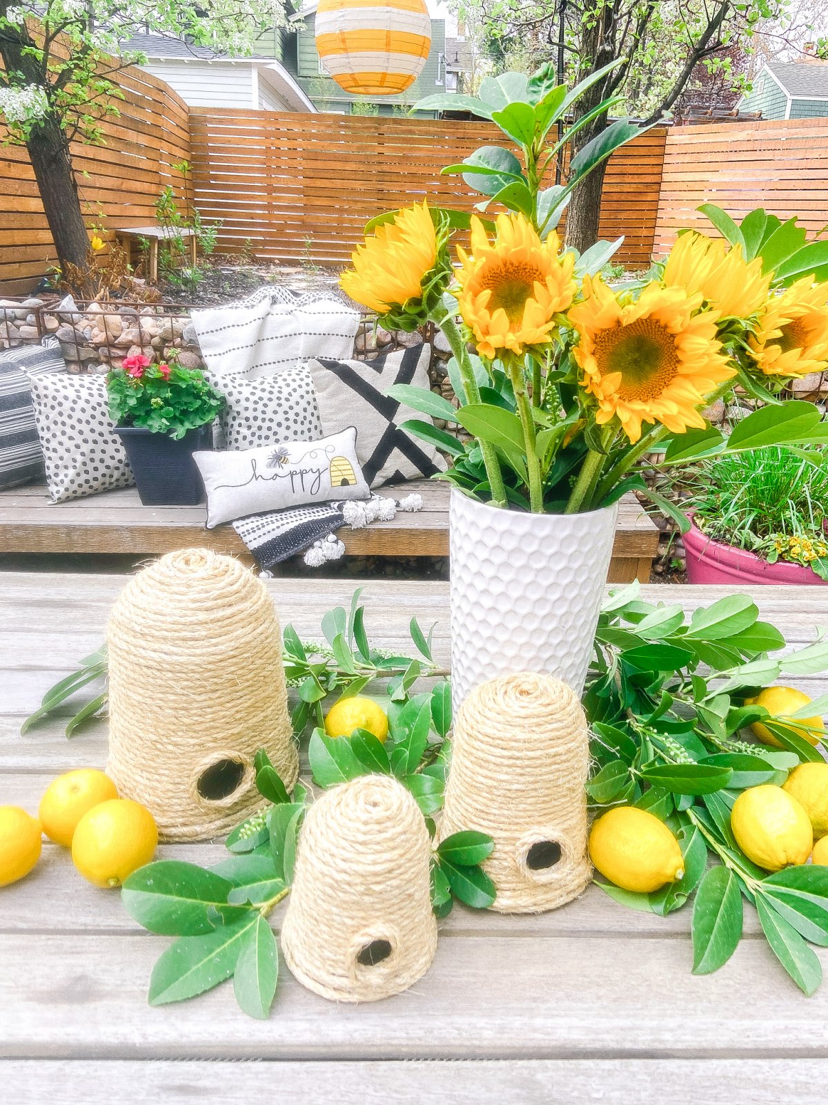 DIY Beehives and Beehive Backyard Inspo! Create cute and inexpensive beehives, add beehive pillows and create a hanging basket garden for a beautiful summer patio!