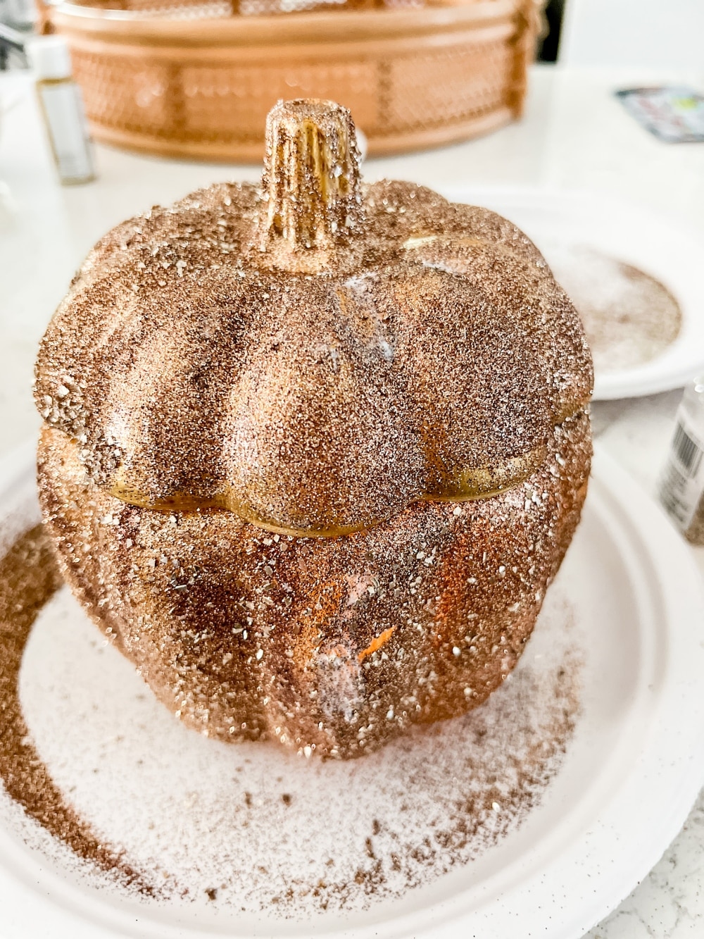 Pottery Barn Inspired Amber Pumpkin Cloches. Turn inexpensive glass pumpkin containers into high end looking cloches by painting and adding glitter! 