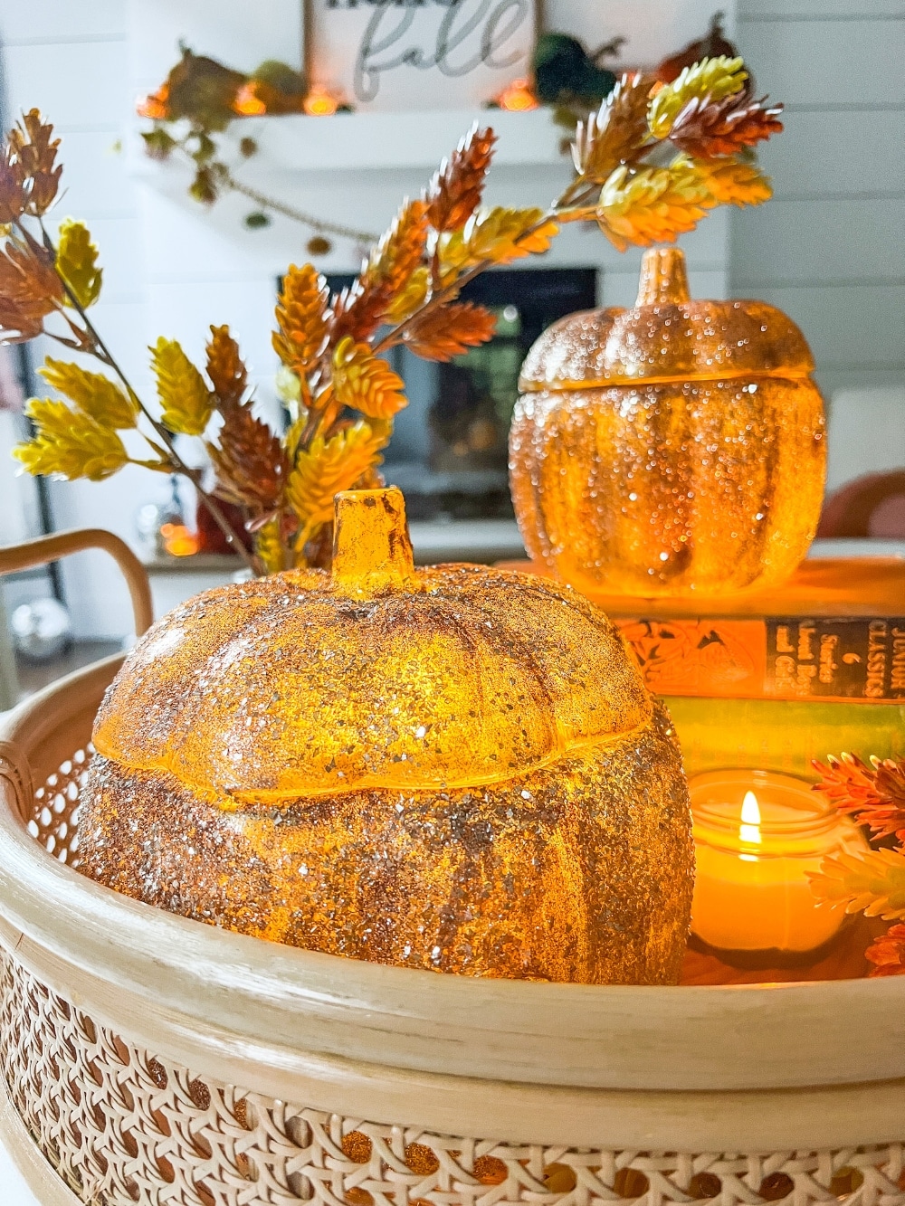 Pottery Barn Inspired Amber Pumpkin Cloches. Turn inexpensive glass pumpkin containers into high end looking cloches by painting and adding glitter! 