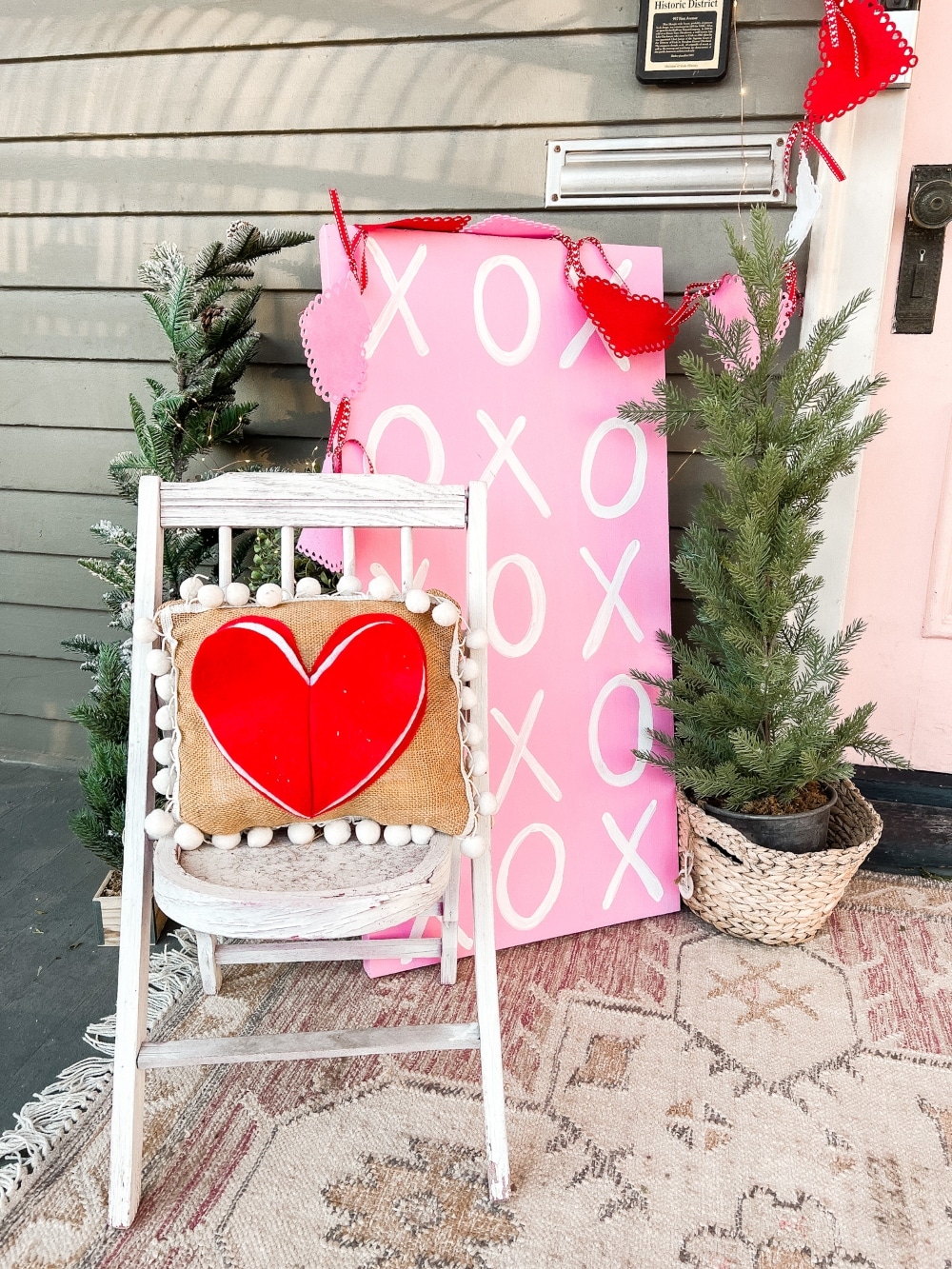 Easy DIY Valentine's Day Porch. Create a lovely Valentine porch with a homemade garland, painted signs, pillows and an easy DIY wreath. 