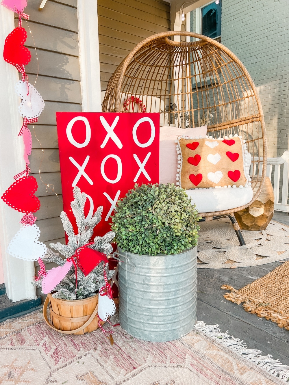 Easy DIY Valentine's Day Porch. Create a lovely Valentine porch with a homemade garland, painted signs, pillows and an easy DIY wreath. 