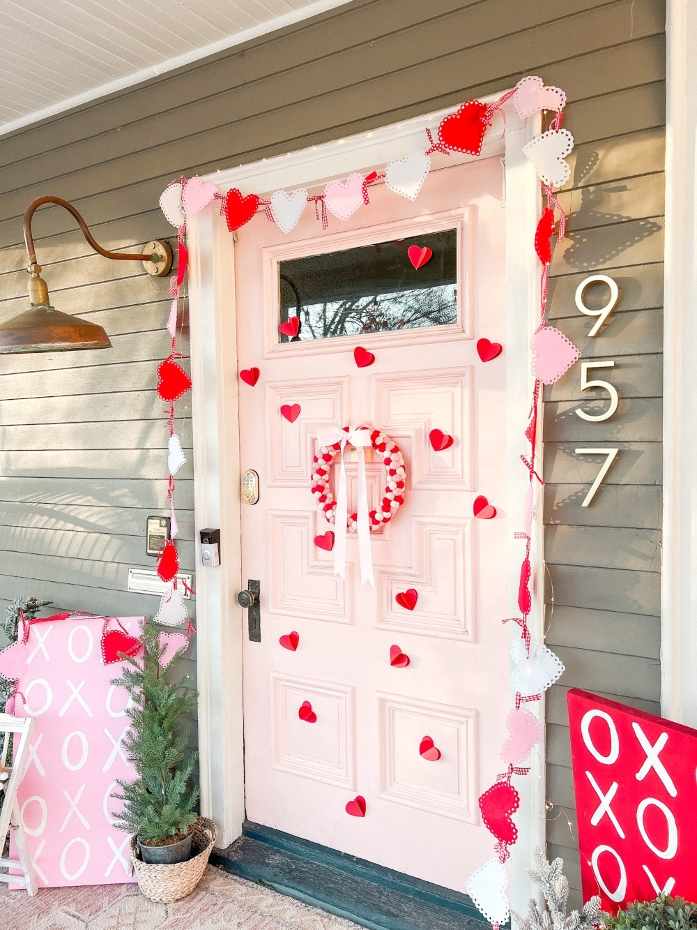 Easy DIY Valentine's Day Porch. Create a lovely Valentine porch with a homemade garland, painted signs, pillows and an easy DIY wreath. 