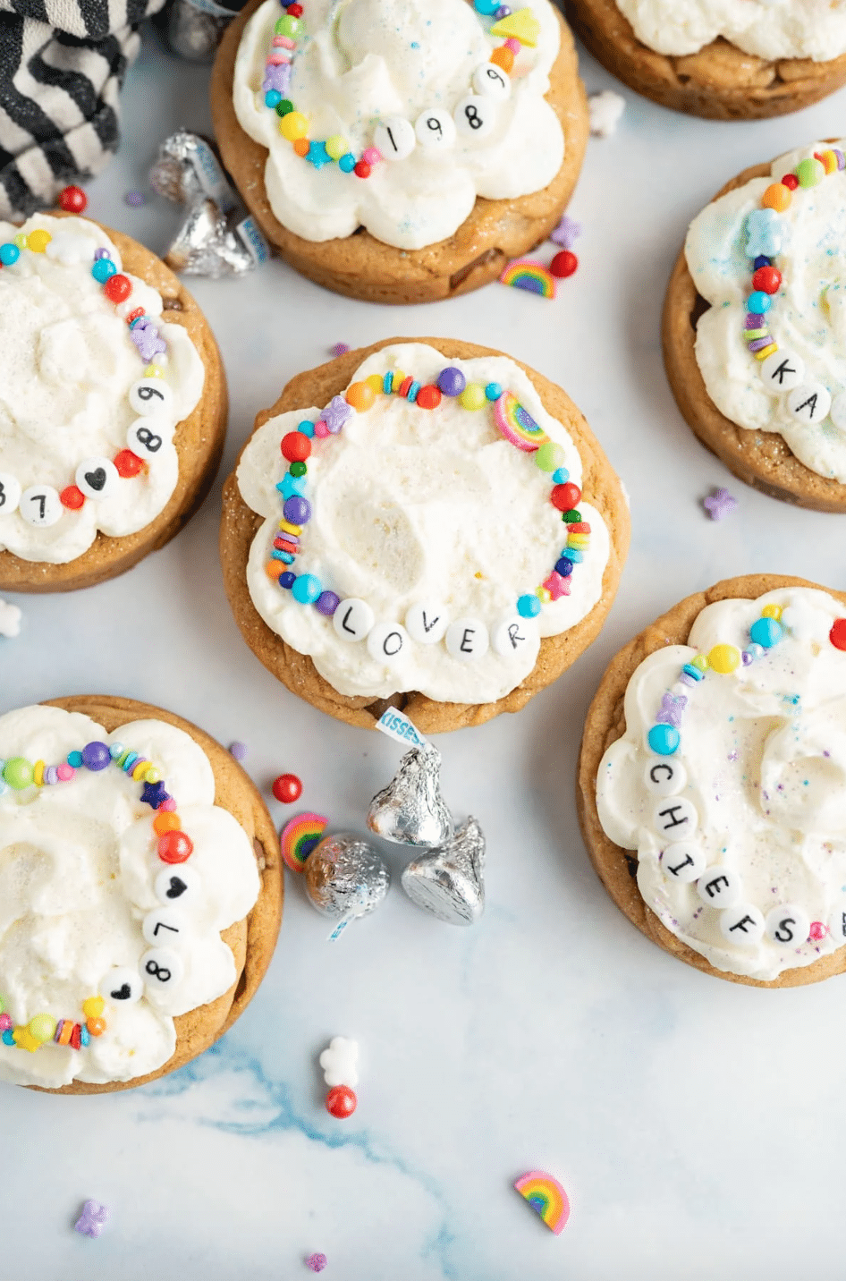 This KARMA(el) blondie filled with mini kisses is inspired by the kiss that was heard around the world. AKA the absolute *moments* Taylor Swift and Travis Kelce shared during her second night of the Eras Tour in Buenos Aires. Topped with a vanilla cloud frosting (feel free to add a lavender haze to it, if you’d like), a custom sprinkle friendship bracelet, and edible glitter, this cookie is truly bejeweled. 