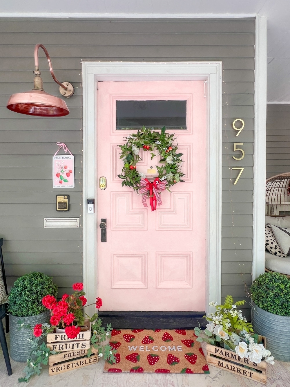 DIY Summer Strawberry Wreath. Create a charming summer strawberry-themed wreath by combining faux strawberries and flowers, lush greenery, and a red bow for a delightful way to decorate your front door.