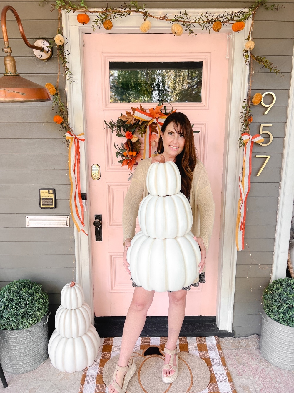 Candy Corn-Colored Fall Porch with Stacked Pumpkins. Create a warm, inviting fall porch with the coolest stacked pumpkins, a vibrant DIY wreath, and layered plaid rugs for a festive, seasonal touch.