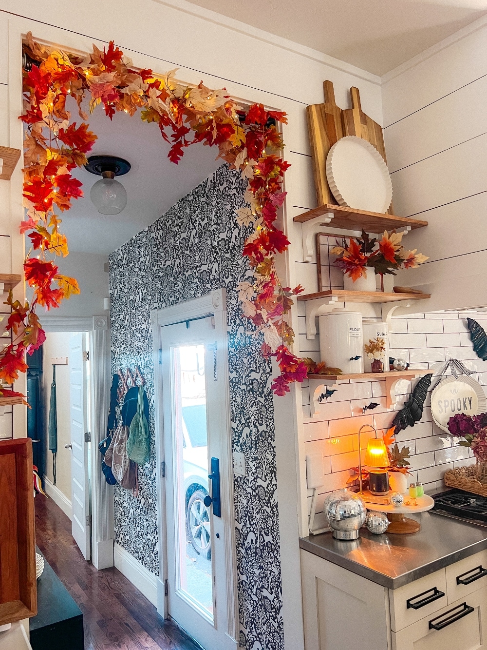 Easy Fall Over the Door Lighted Garland. Create an easy and festive fall over-the-door garland using inexpensive leaf garlands, twinkle lights, and a shower curtain rod, perfect for autumn decor.