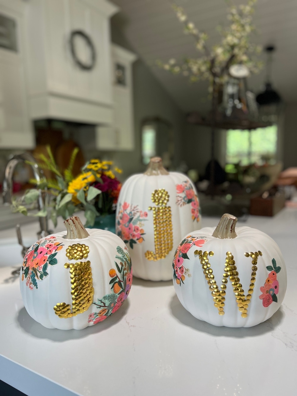 DIY No-Carve Monogram Pumpkin. Create a stylish, no-carve monogram pumpkin for fall using gold thumbtacks and decoupaged florals cut from napkins—perfect for adding a personal touch to your seasonal decor!