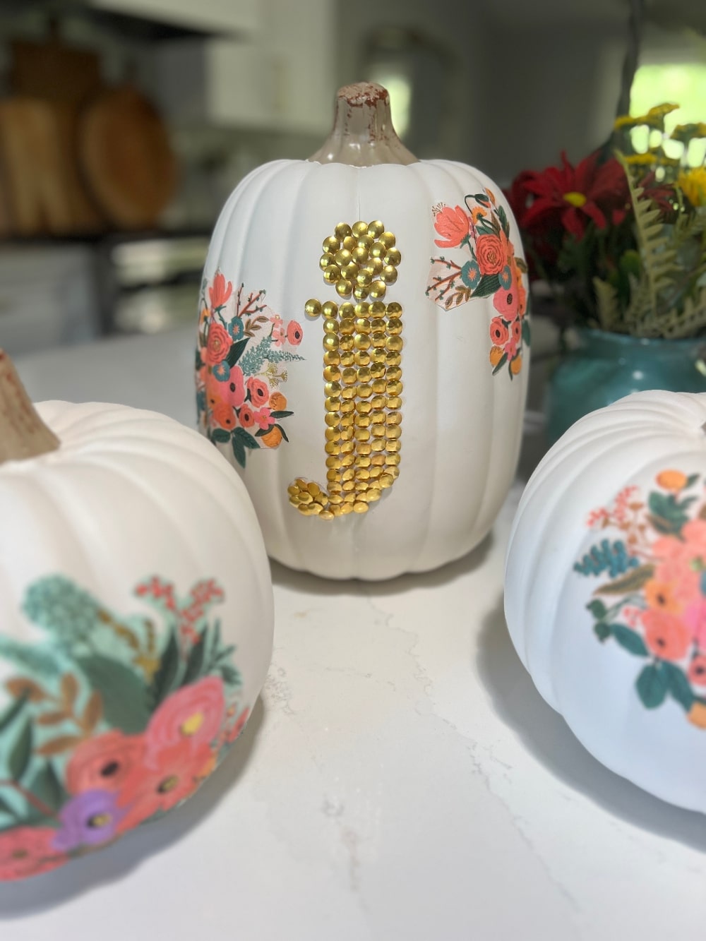 DIY No-Carve Monogram Pumpkin. Create a stylish, no-carve monogram pumpkin for fall using gold thumbtacks and decoupaged florals cut from napkins—perfect for adding a personal touch to your seasonal decor!