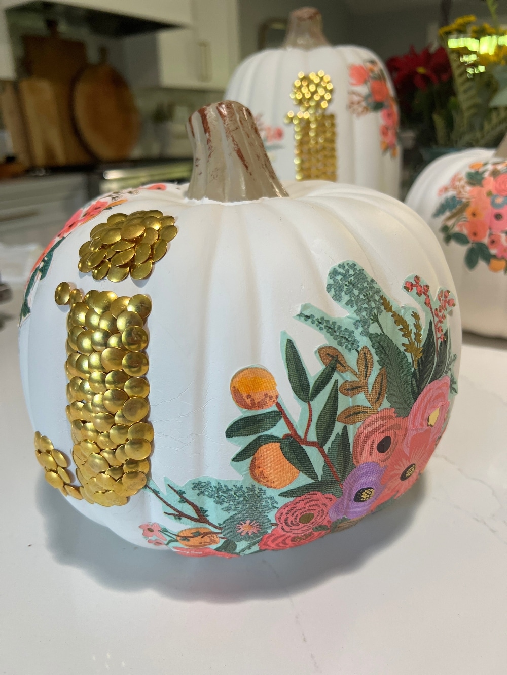 DIY No-Carve Monogram Pumpkin. Create a stylish, no-carve monogram pumpkin for fall using gold thumbtacks and decoupaged florals cut from napkins—perfect for adding a personal touch to your seasonal decor!