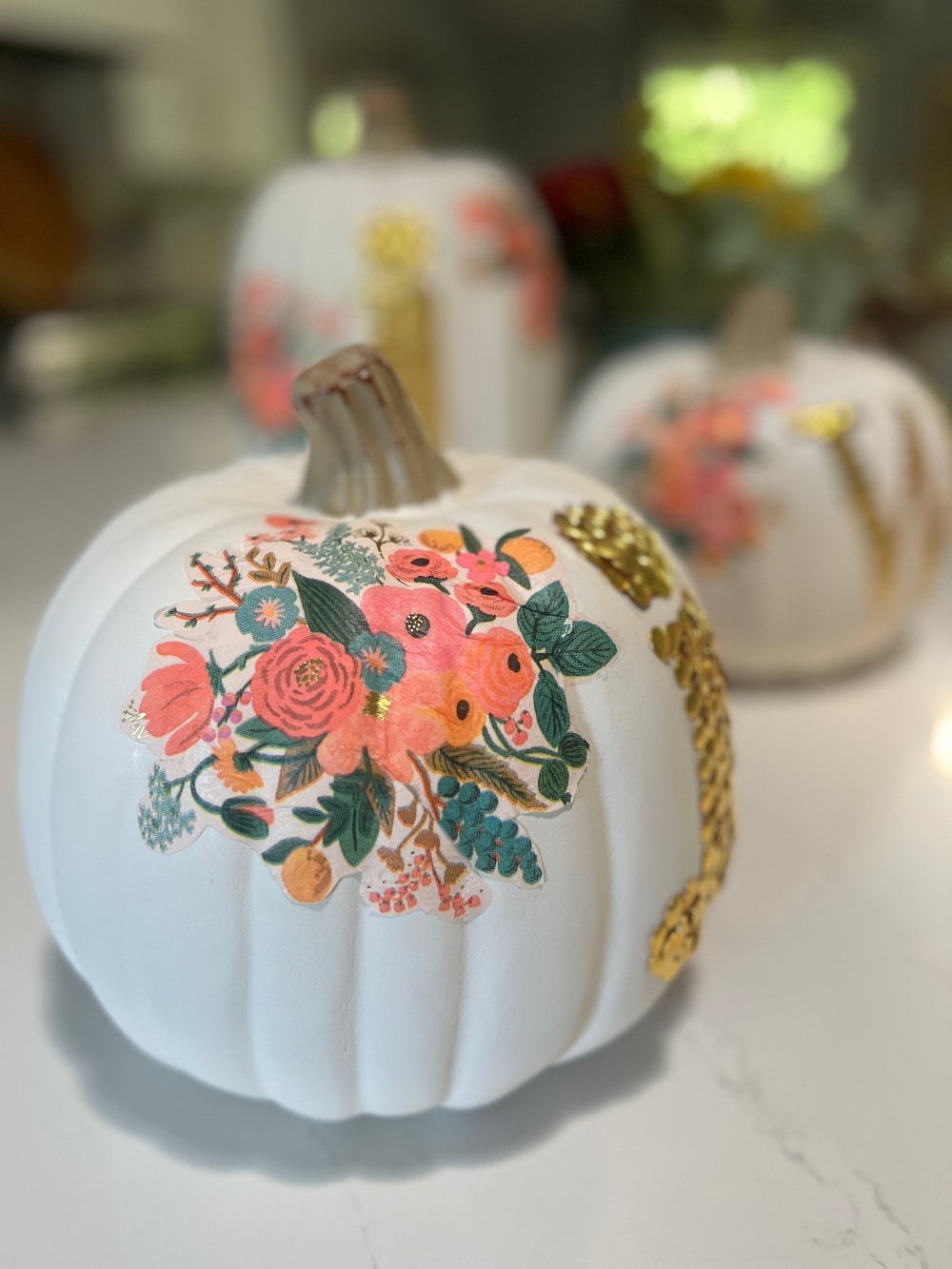 DIY No-Carve Monogram Pumpkin. Create a stylish, no-carve monogram pumpkin for fall using gold thumbtacks and decoupaged florals cut from napkins—perfect for adding a personal touch to your seasonal decor!