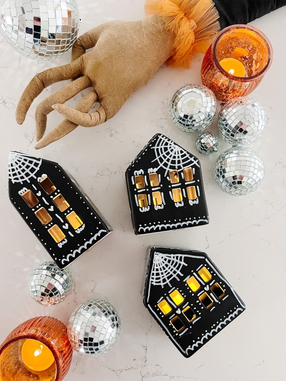 DIY Halloween Gingerbread Village. Make a DIY Spooky Gingerbread Village by painting small houses black and adding spooky touches like webs and ghosts for a fun Halloween twist! 