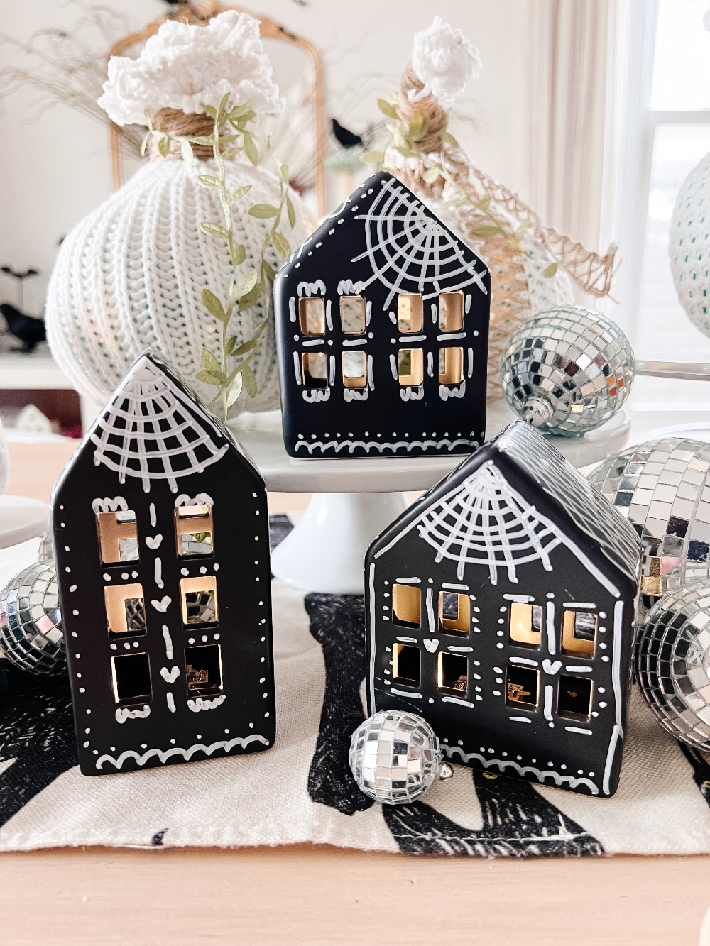 DIY Halloween Gingerbread Village. Make a DIY Spooky Gingerbread Village by painting small houses black and adding spooky touches like webs and ghosts for a fun Halloween twist! 