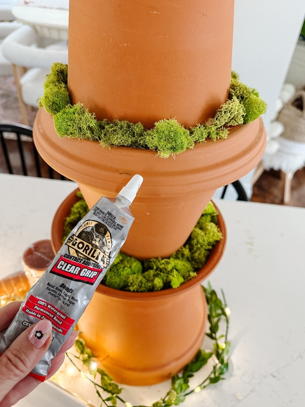 DIY Terra Cotta Pot Fairy Garden – A Magical Spring Craft. Create a whimsical stacked terra cotta fairy garden with clay doors, moss, and magical miniatures to add charm to your spring porch!