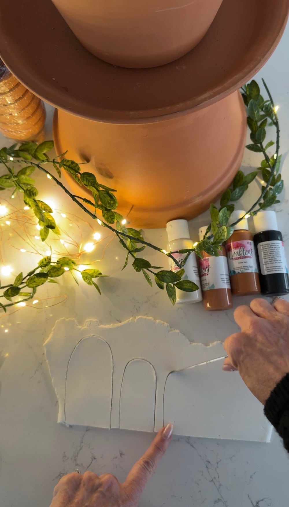 DIY Terra Cotta Pot Fairy Garden – A Magical Spring Craft. Create a whimsical stacked terra cotta fairy garden with clay doors, moss, and magical miniatures to add charm to your spring porch!