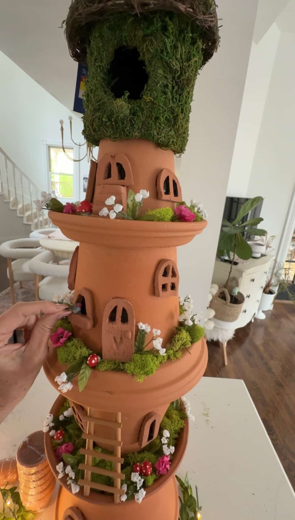 DIY Terra Cotta Pot Fairy Garden – A Magical Spring Craft. Create a whimsical stacked terra cotta fairy garden with clay doors, moss, and magical miniatures to add charm to your spring porch!