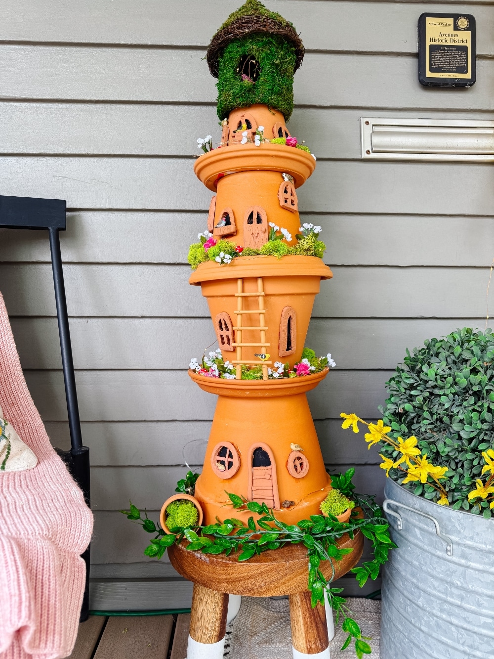 DIY Terra Cotta Pot Fairy Garden – A Magical Spring Craft. Create a whimsical stacked terra cotta fairy garden with clay doors, moss, and magical miniatures to add charm to your spring porch!